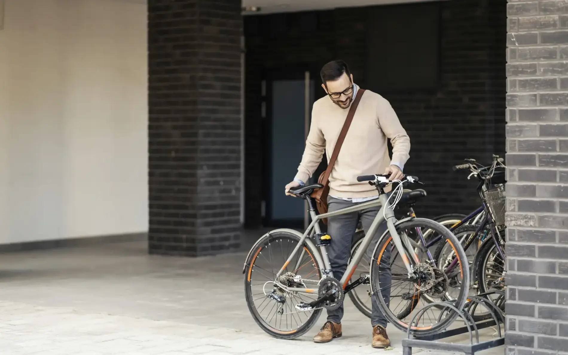 Mann stellt Fahrrad bei Abstellanlage ab