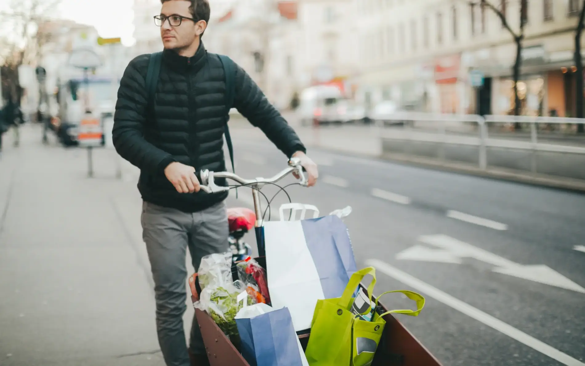 Mann fährt mit Transportrad voller Gepäck und Sackerl