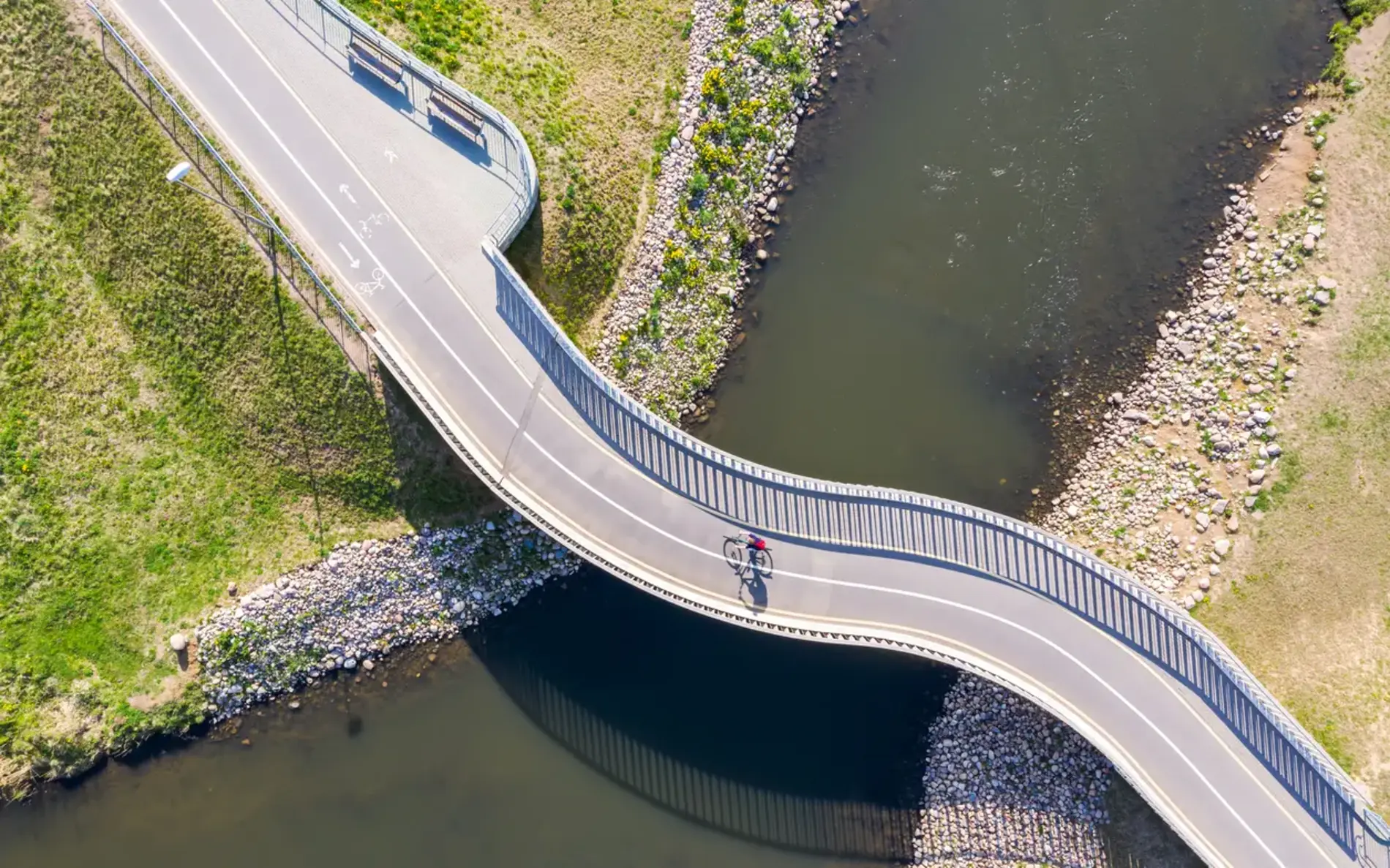 Vogelperspektive einer Radbrücke über einen Fluss